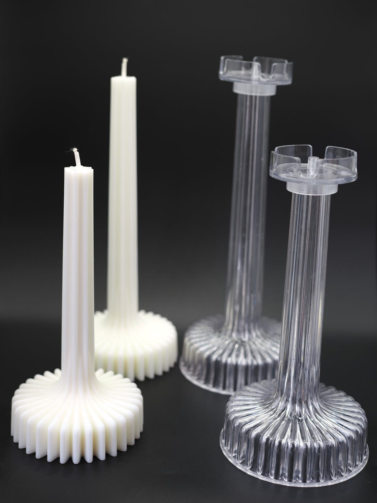 two pleated candles and their moulds